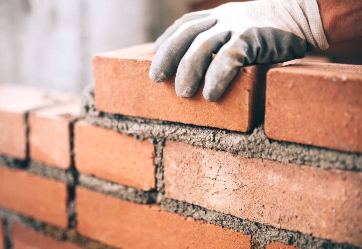 Bogdanhoda close-up-of-industrial-bricklayer-installing-bricks-on-construction-picture-id622800884