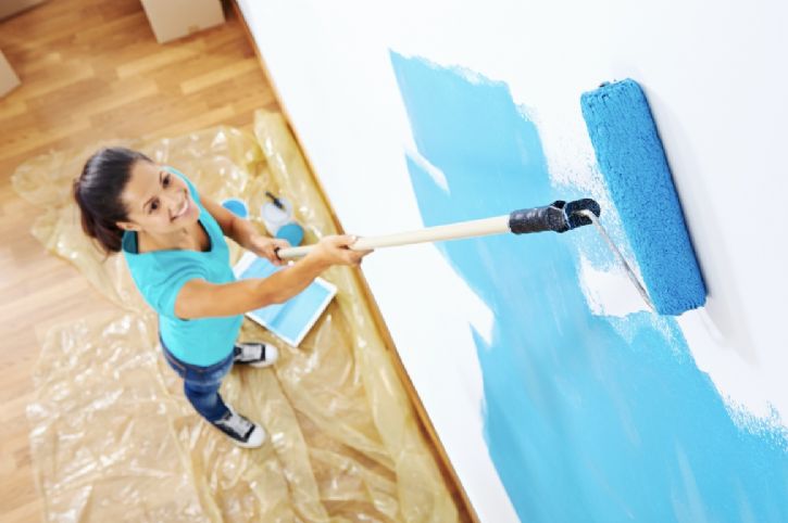 Woman painting blue paint