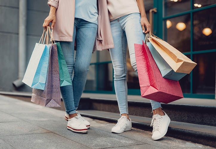 Two female shoppers with bags retail shopping shutterstock_1230910540